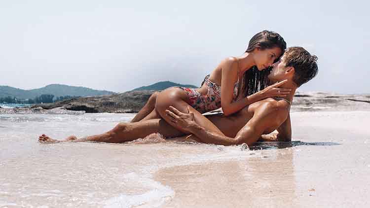 Beautiful models passion couple kissing and embracing in the sea water.