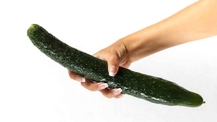 Beautiful woman's hand holding a big cucumber