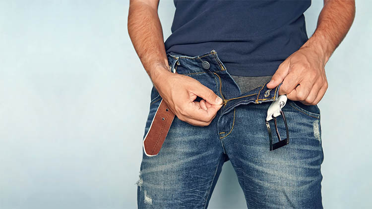 Close up shot of man in jeans with open zipper. unbuttoned blue pants