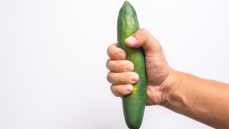Man holding cucumber imitating a penis